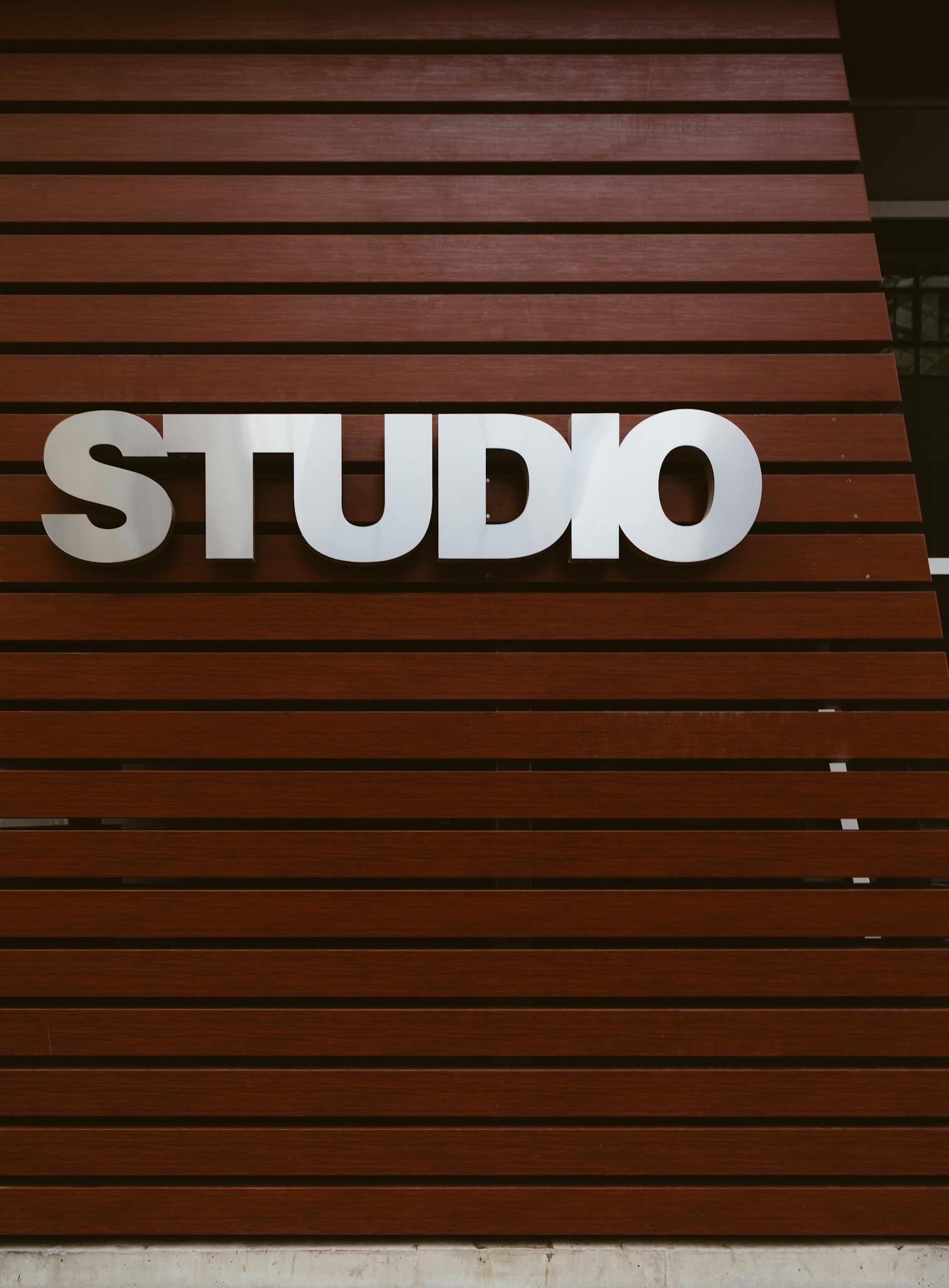 Sleek studio sign on a modern wooden panel exterior wall, perfect for design and architecture themes.